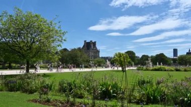 Paris, Fransa. Haziran 2022. Tuileries, Paris 'in merkezindeki en eski bahçedir. Burada insanlar yeşillik boyunca uzanan uzun caddelerde dolaşmaya geliyorlar. Kamera görüntüsü.