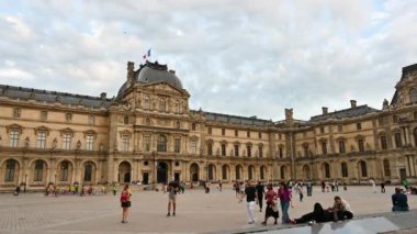 Fransa, Paris, Haziran 2022. Güzel bir günde, Louvre 'un büyük meydanında, büyük cam piramit göze çarpar. İnsanlar avluda yürüyor..