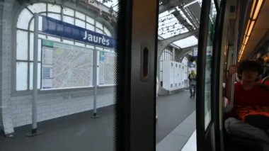 Paris, France, June 2022. At the jaurs metro stop the departure in POV from inside a train the sliding doors close and the train starts, some travelers walk on the platform.