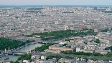 Paris, Fransa, Haziran 2022. Şehrin altın saati Eyfel Kulesi 'nin tepesinden toplanıyor. Soldaki Alexander III köprüsünde ve merkezdeki Tuileries bahçelerinde dönme dolap var..