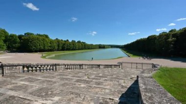 Versailles, Paris, France, June 2022. Beautiful pan footage from the Grand Trianon towards the branch of the grand canal de Versailles, makes the observer understand the vastness of the palace park.