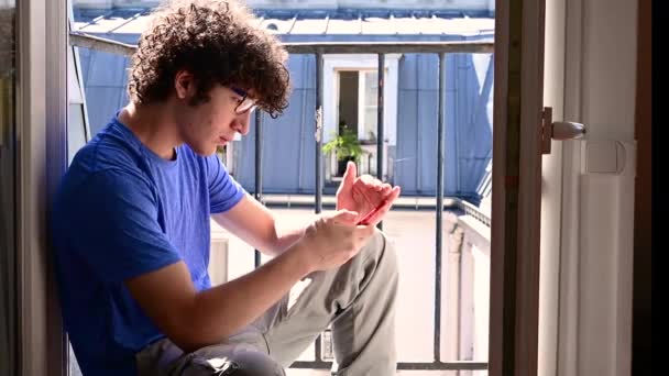 Footage Handsome Caucasian Young Man Sitting Window Using His Mobile — Stok video