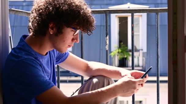 Footage Handsome Caucasian Young Man Sitting Window Using His Mobile – Stock-video