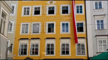 Salzburg, Avusturya, Ağustos 2022. Mozart 'ın eski kasabadaki evinin kamera görüntüleri. Parlak sarı cephede Mozart 'ın evi yazılı..