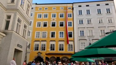 Salzburg, Avusturya, Ağustos 2022. Mozart 'ın eski kasabadaki evinin yakınlaştırılmış görüntüleri. Parlak sarı cephede Mozart 'ın evi yazılı..