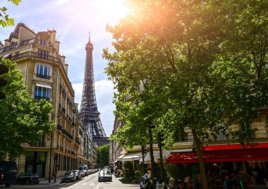 Paris, France. June 2022. Amazing shot of the Eiffel Tower rising between the buildings of the old town and the canopy of trees.