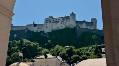 Salzburg, Avusturya, Ağustos 2022. Tepenin tepesindeki kalenin güzel manzarası, bir kemer onu çerçeveler.