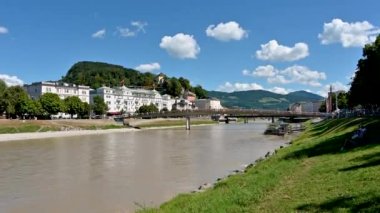 Salzburg, Avusturya, Ağustos 2022. Güzel pov görüntüleri nehir kıyısındaki çimlerin üzerinde Makartsteg Köprüsü 'ne (Love Locks Bridge) doğru yürüyor. Güzel bir yaz günü.