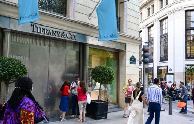 Paris, Fransa, Haziran 2022. Tarihi merkezde Tiffany marka lüks bir mağaza var. Yoldan geçenler ve turistler.