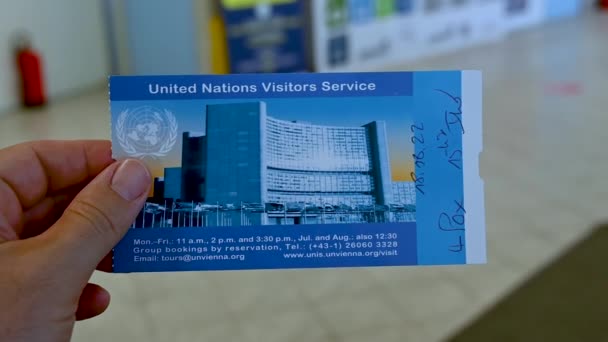2022年8月 奥地利维也纳 进入联合国总部的游客入场券的慢镜头 一个白人男子的左手用手指握住它 — 图库视频影像