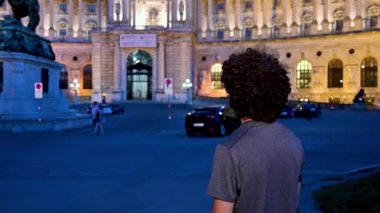 Viyana, Avusturya, Ağustos 2022. İmparatorluk Sarayı 'nın mavi saatinde selfie çeken bir adamın güzel görüntüleri. Hofburg, dünyanın en büyük komplekslerinden biridir. Habsburg Hanedanı..