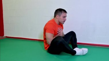 Genç beyaz erkek sporcu antrenmanlarıyla karın egzersizi yaparak güzel görüntüler. Beyaz duvarlı arkaplan, boşluğu kopyala.