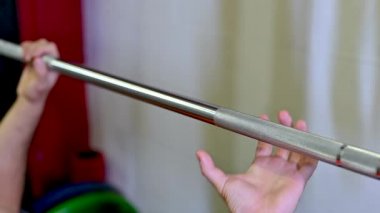 Göğüs presini başlatmak için ağırlığı tutan elin güzel yavaş çekim görüntüleri. Bulanık arkaplanda diğer el hazır. Motivasyon görüntüleri.
