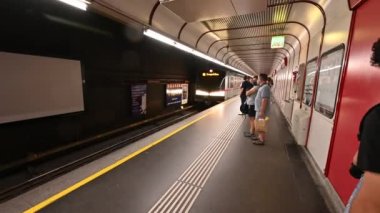 Viyana, Avusturya, Ağustos 2022. Metro durağındaki görüntülerde tünelden çıkan treni ve platforma yaklaşan insanları görebilirsiniz..