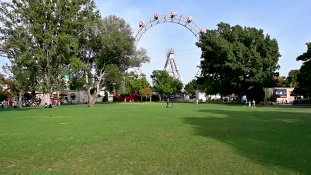2022年8月 奥地利维也纳 在城市的大型游乐园 普拉特 你会立即注意到大型老式摩天轮的Pov镜头 人们在草坪上休息 — 图库视频影像