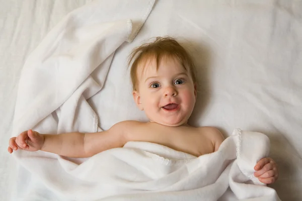 Baby flicka under den vita filten — Stockfoto