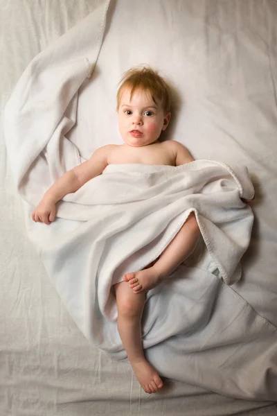 Baby girl under the white blanket — Stock Photo, Image
