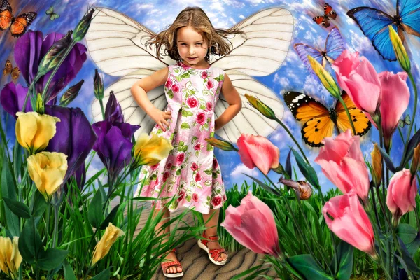 Симпатична маленька дівчинка з крилами метелика в квітах Стокове Зображення