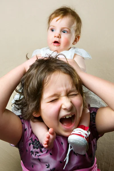 Kız kardeşinin boynundan oturan kız