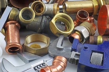 Tesisatçı 's borular ve bağlantı parçaları rasgele karışımı bakır boru ve pirinç parçaları için ideal bir Web sitesi üstbilgi arka planı olarak kullanma