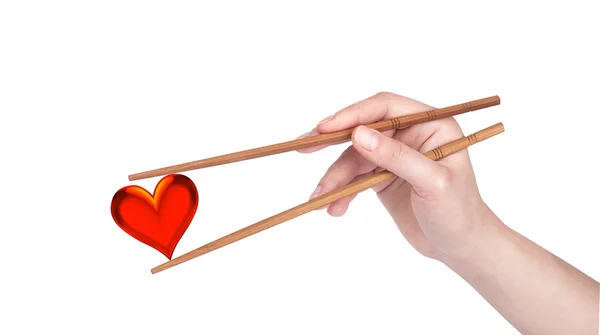 Liebeskonzept mit Frauenhand, Herz und Essstäbchen — Stockfoto