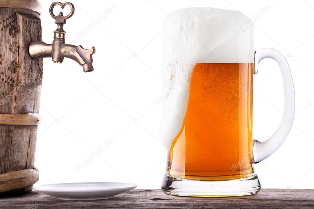 Glass of beer with barrel on a wooden table