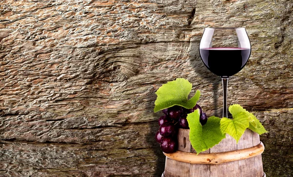 Σταφύλια και ποτήρι κρασί για ένα ξύλινο βαρέλι vintage — Φωτογραφία Αρχείου