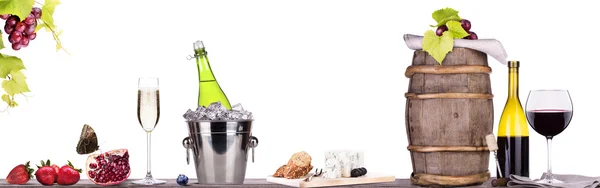 Winogrona, wiadro lodu z szampanem na stole — Zdjęcie stockowe