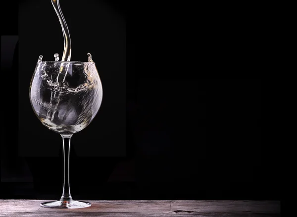 Elegantes Weißweinglas auf schwarzem Hintergrund — Stockfoto