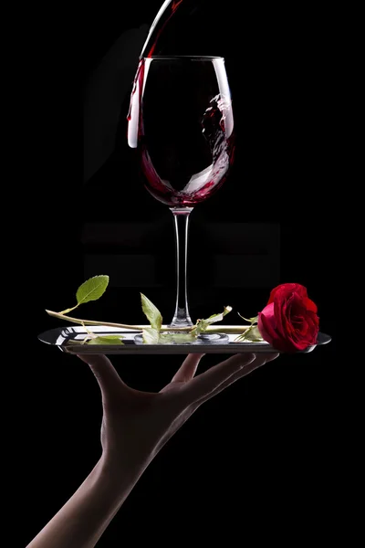 Glass of red wine and rose on black — Stock Photo, Image