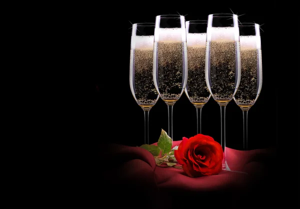 Champagne glass on black and red silk with flower — Stock Photo, Image