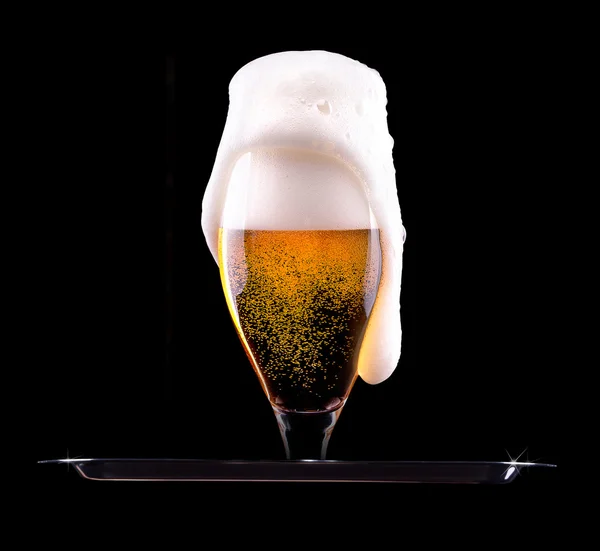 Beer into glass on a black — Stock Photo, Image