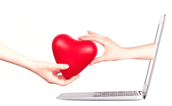 Hand mit Herz - Geschenk und Laptop — Stockfoto