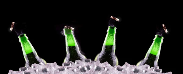 Open wet beer bottles on ice — Stock Photo, Image