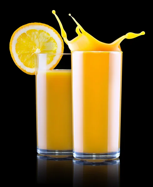 Färsk apelsinjuice i glas med färgstänk — Stockfoto