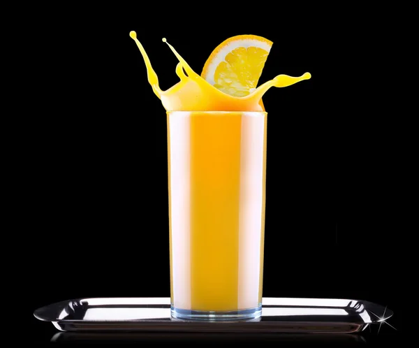 Свіжий апельсиновий сік у склянці з бризкою — стокове фото