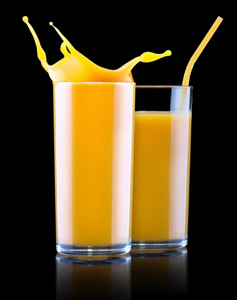 Färsk apelsinjuice i glas med färgstänk — Stockfoto