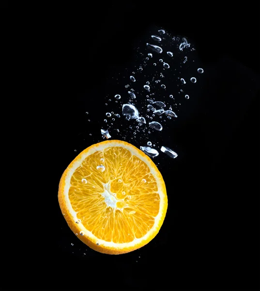 Slice of orange in the water with bubbles — Stock Photo, Image