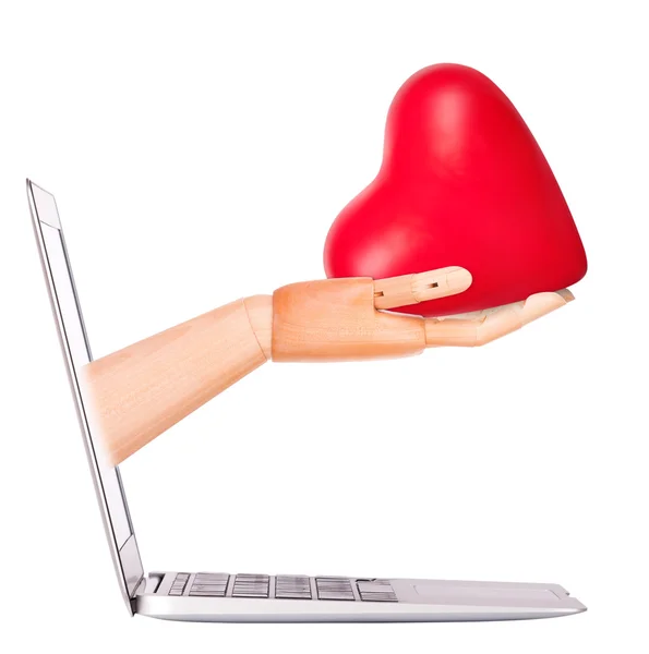 La mano de madera con el corazón - el regalo y el portátil —  Fotos de Stock