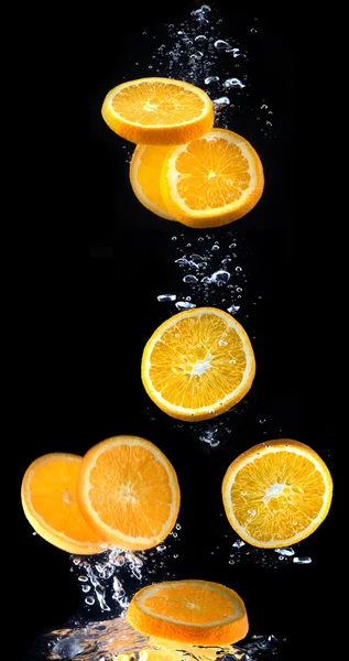 Plasterkiem pomarańczy w wodzie z bąbelkami — Zdjęcie stockowe