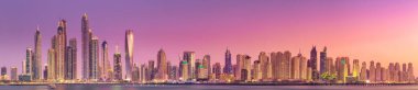 Geceleri Dubai Marina Körfezi 'nin modern binaları. Arka planda ışıklar, Palm Jumeirah, BAE manzaralı.