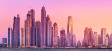 Palm Jumeirah, Birleşik Arap Emirlikleri Dubai Marina defne görünümünden on sunset altın yansıması ile modern binalar.