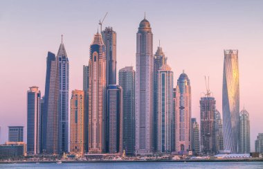 Palm Jumeirah, Birleşik Arap Emirlikleri Dubai Marina defne görünümünden on sunset altın yansıması ile modern binalar.
