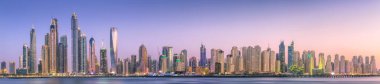 Palm Jumeirah, Birleşik Arap Emirlikleri Dubai Marina defne görünümünden on sunset altın yansıması ile modern binalar.
