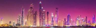 Geceleri Dubai Marina Körfezi 'nin modern binaları. Arka planda ışıklar, Palm Jumeirah, BAE manzaralı.