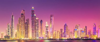 Geceleri Dubai Marina Körfezi 'nin modern binaları. Arka planda ışıklar, Palm Jumeirah, BAE manzaralı.