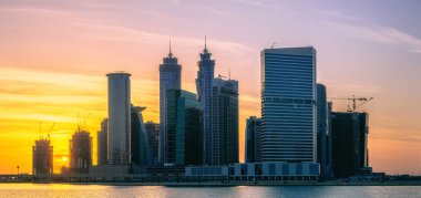 Dubai 'nin şehir manzarası ve panoramik Business Bay manzarası ve sabahları gökdelenlerin su üzerindeki yansıması, BAE.