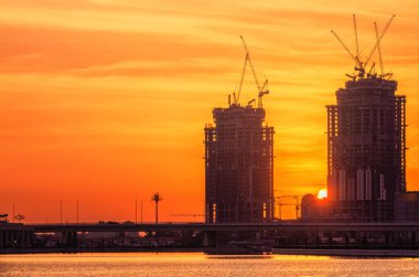 Dubai 'nin şehir manzarası ve panoramik Business Bay manzarası ve sabahları gökdelenlerin su üzerindeki yansıması, BAE.