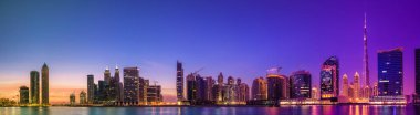 Cityscape Dubai ve gökdelenler su yansıma mor gündoğumu, BAE sırasında iş Körfezi'nin panoramik