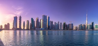 Cityscape Dubai ve gökdelenler su yansıma mor gündoğumu, BAE sırasında iş Körfezi'nin panoramik